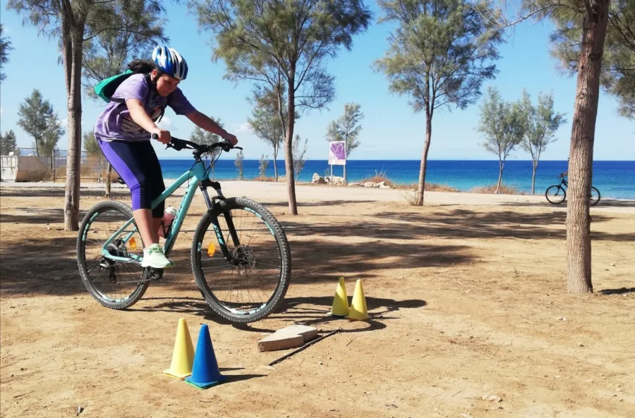 A young rider working through a cone course under pine trees by the beach