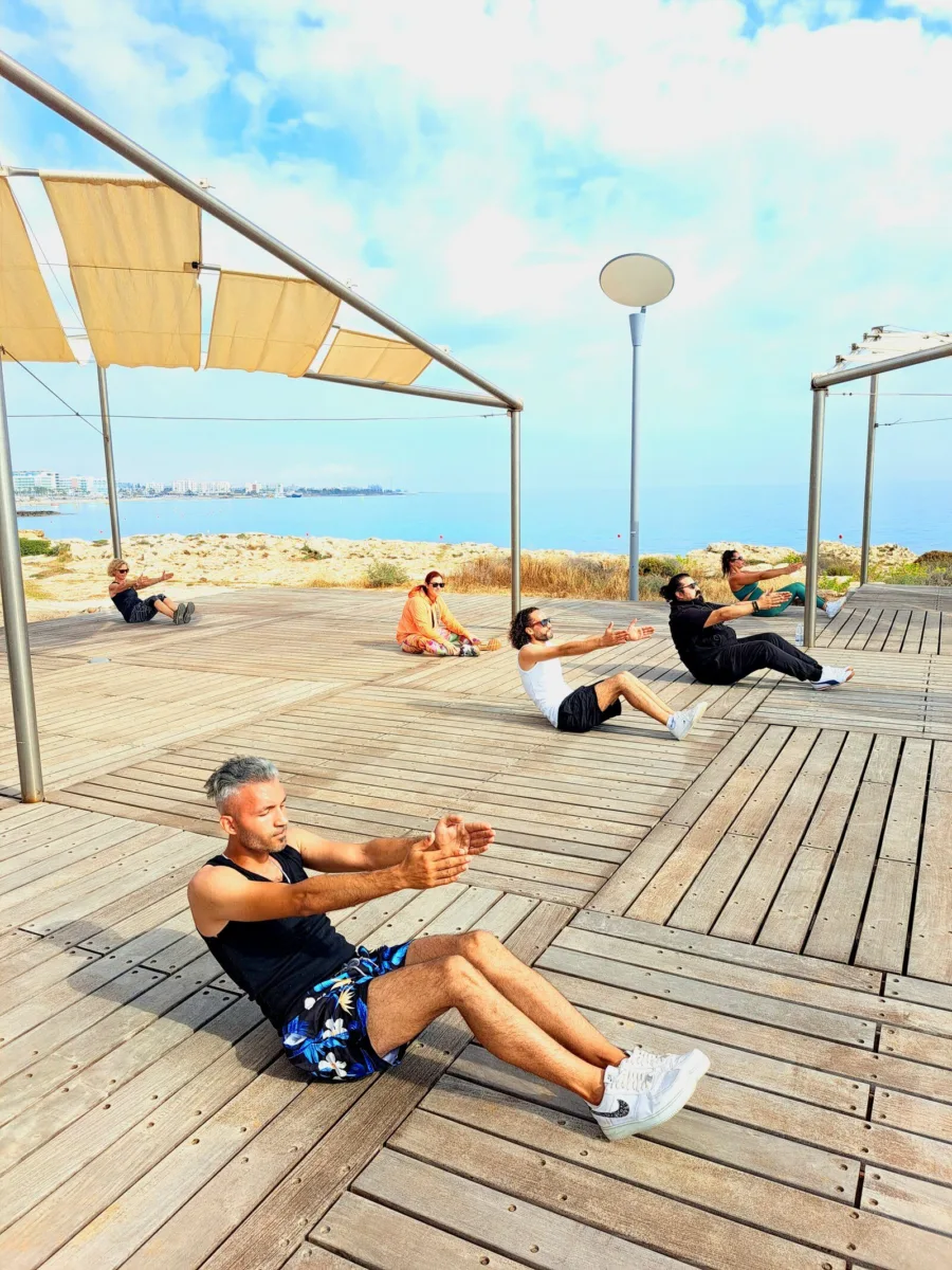Two people working through a core set on the wooden seafront boardwalk