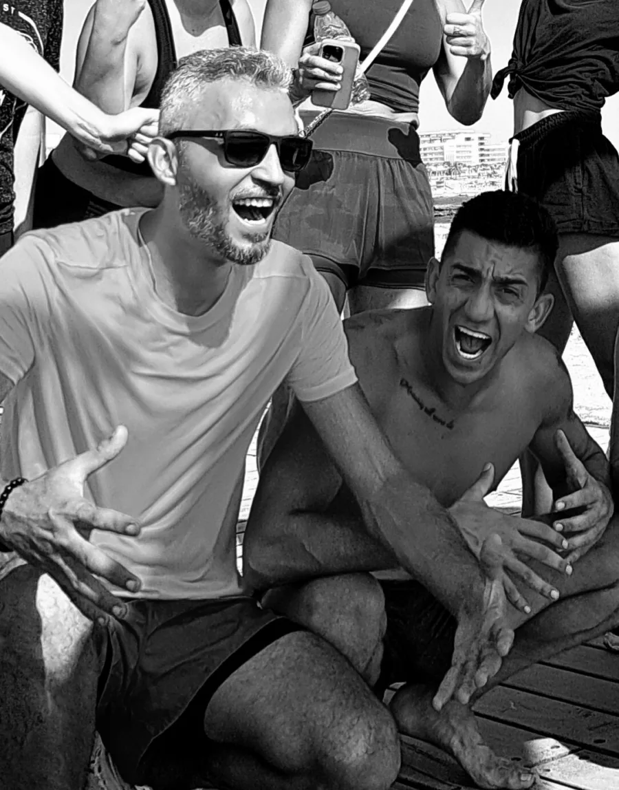 Ramo and a training partner laughing after a set, in black and white