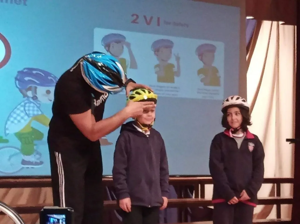 Ramo fitting a helmet on a school pupil during a road-safety talk