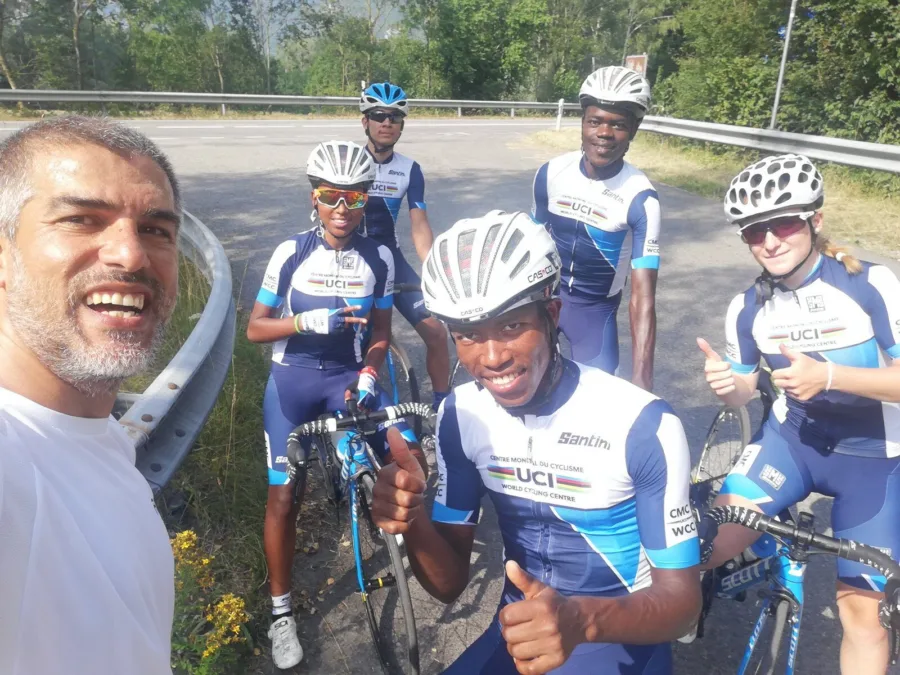 Ramo with a group of junior riders in team kit beside a road
