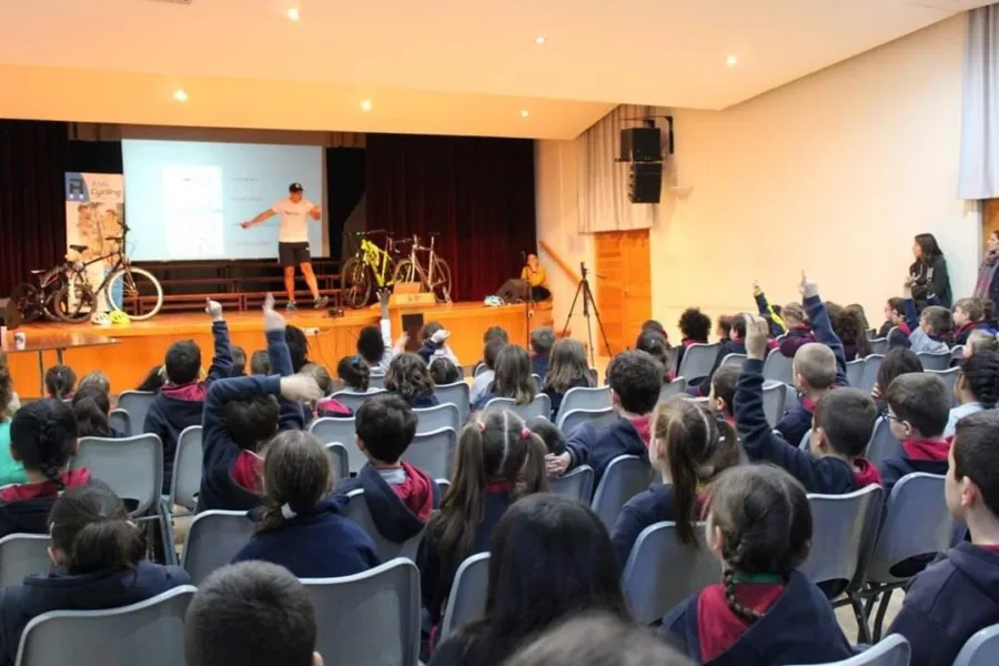 A cycling presentation to a school audience with road bikes lined up on the stage