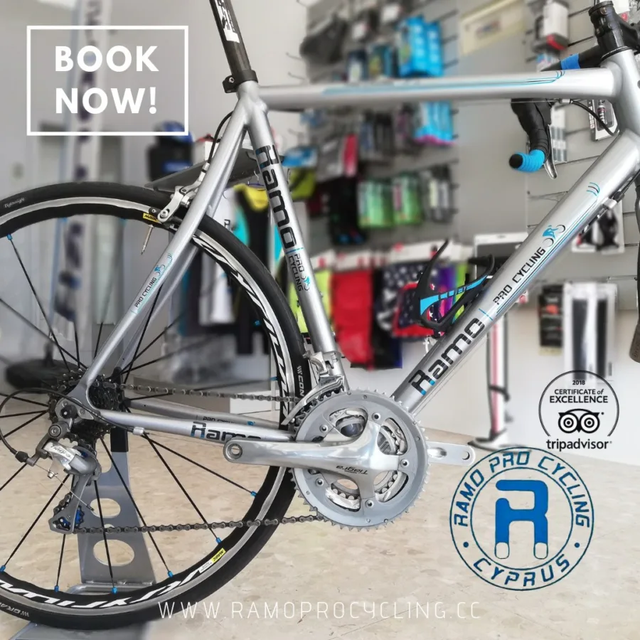 Poster: a road bike on a stand in front of the shop wall of accessories, captioned BOOK NOW! with a 2018 TripAdvisor Certificate of Excellence