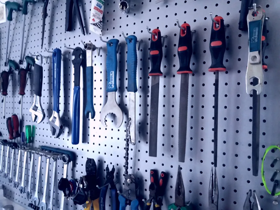 A workshop pegboard hung with spanners, chain whips, cone wrenches, files and pliers