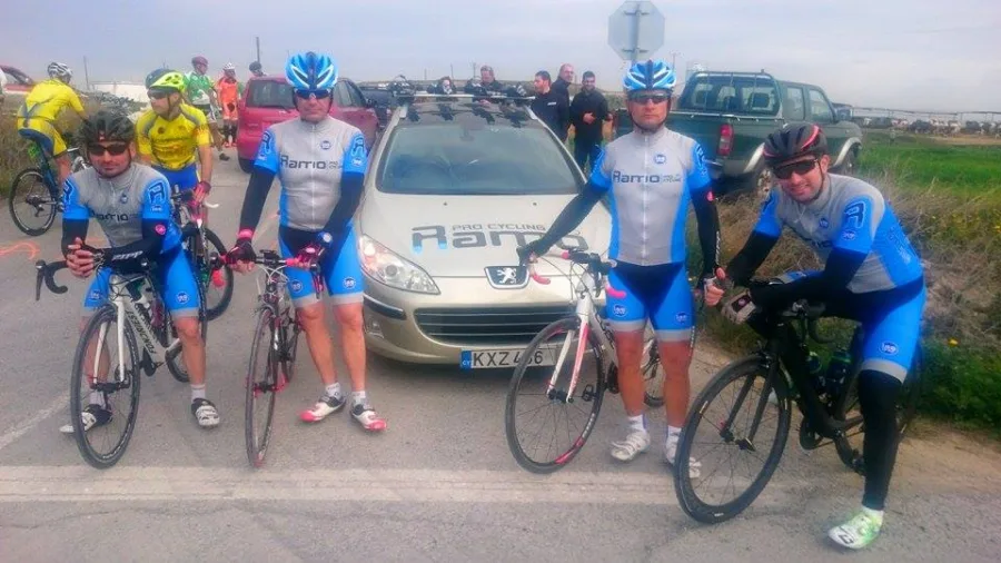 Riders in Ramo kit gathered around the team car before a race