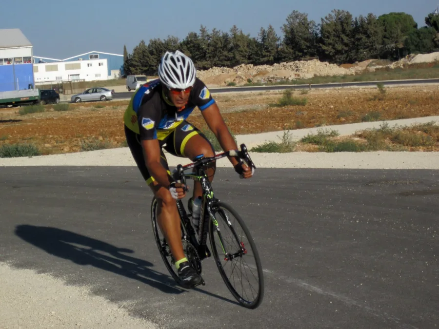 A rider in dark team kit riding on an open road