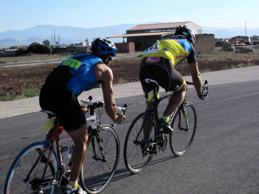Two riders in triathlon kit riding side by side on a road