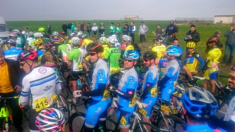 A dense bunch of riders in colourful kit packed together at a race start