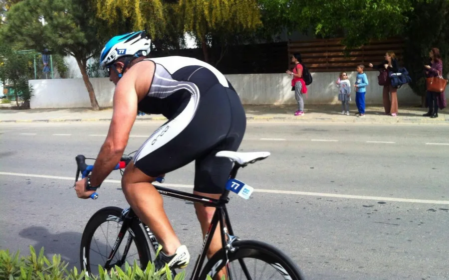 A rider in a black and white tri suit low on a time-trial bike