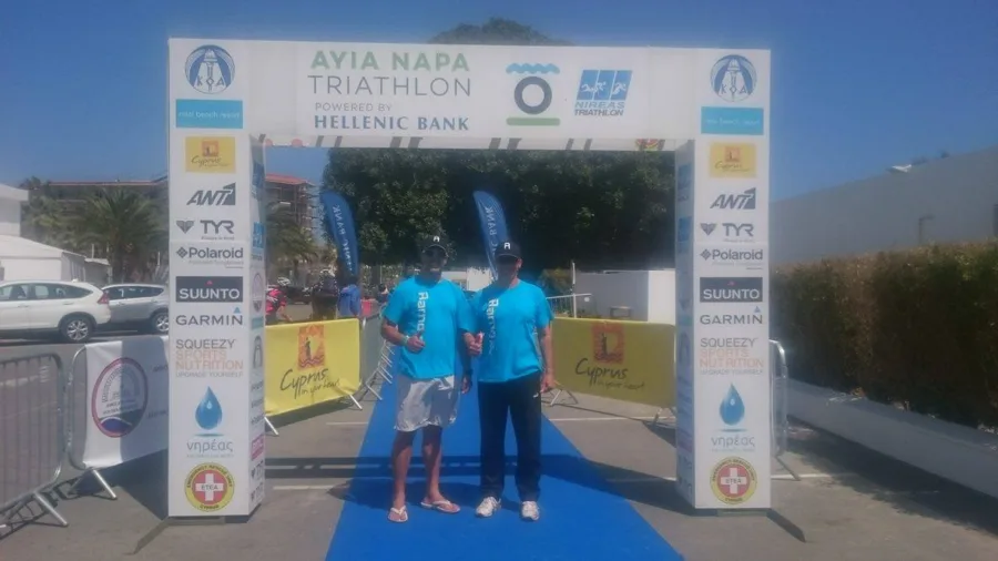Two men standing under the finish arch of the Ayia Napa Triathlon