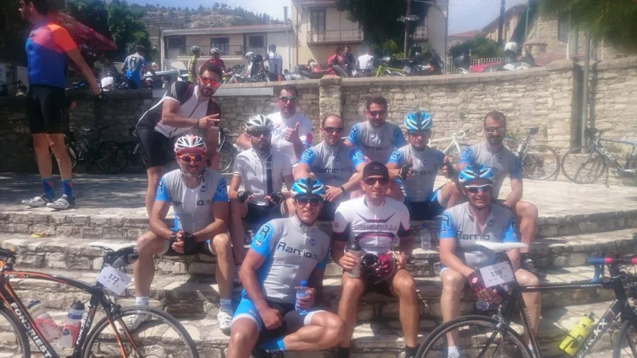 A group of riders sitting along a stone wall with their bikes
