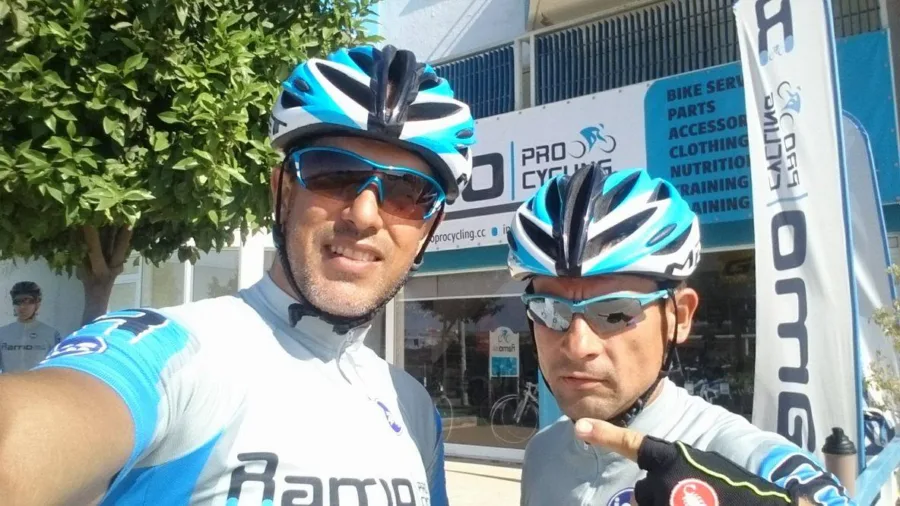 Two riders in Ramo kit in front of the shop