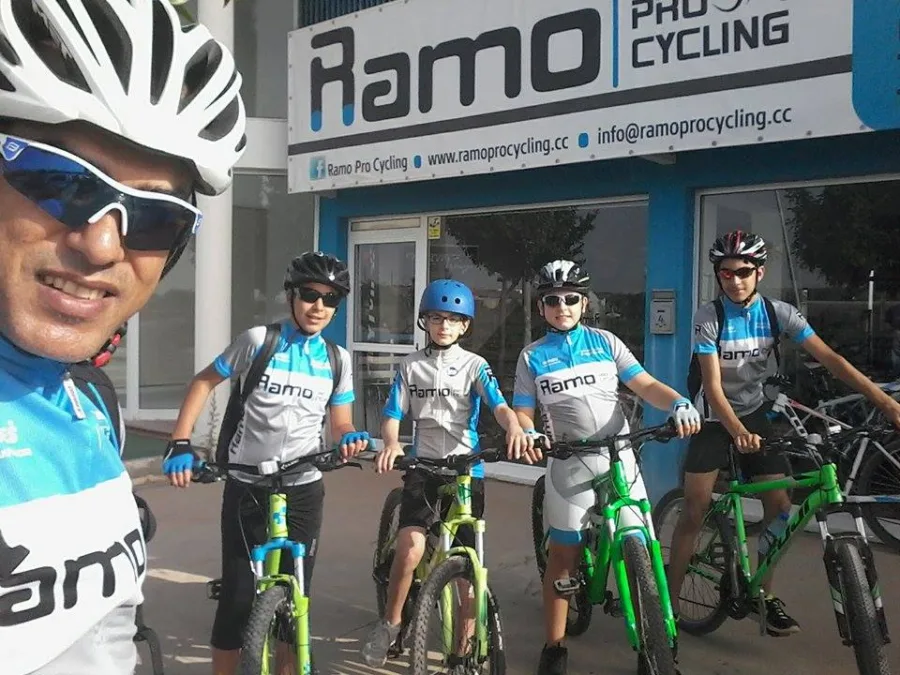 Riders in Ramo kit with mountain bikes outside the shop
