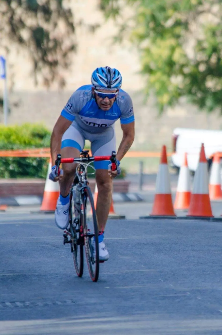 A rider in Ramo kit riding through a coned section of a closed road