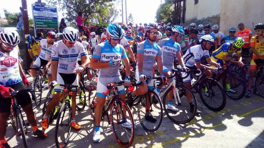 A packed bunch of riders in team kit at the start of a road race