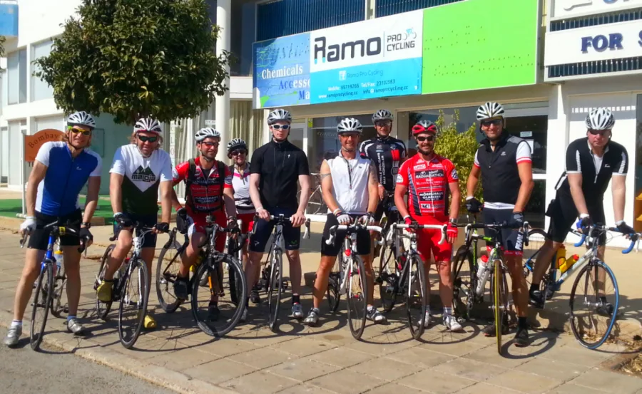 A group of riders with their bikes lined up on the pavement outside the Ramo shop