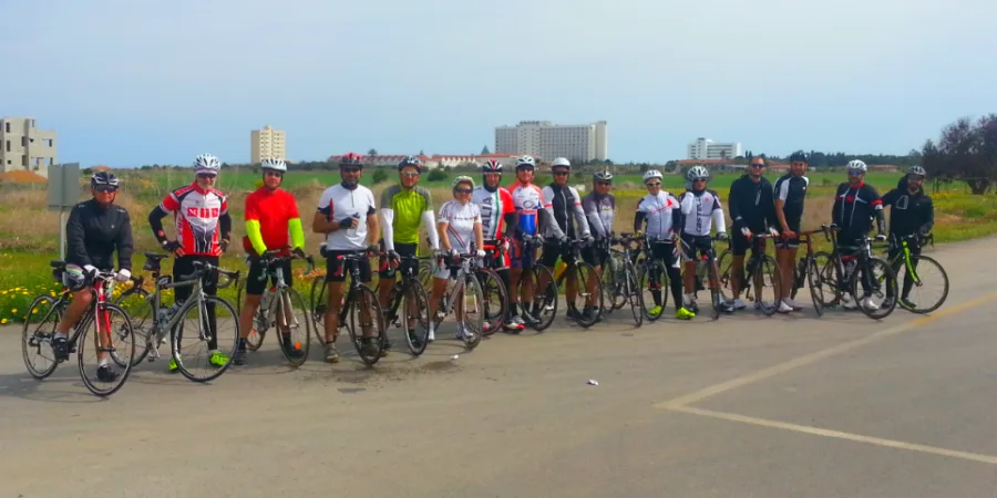 A long line of riders standing with their bikes across a road