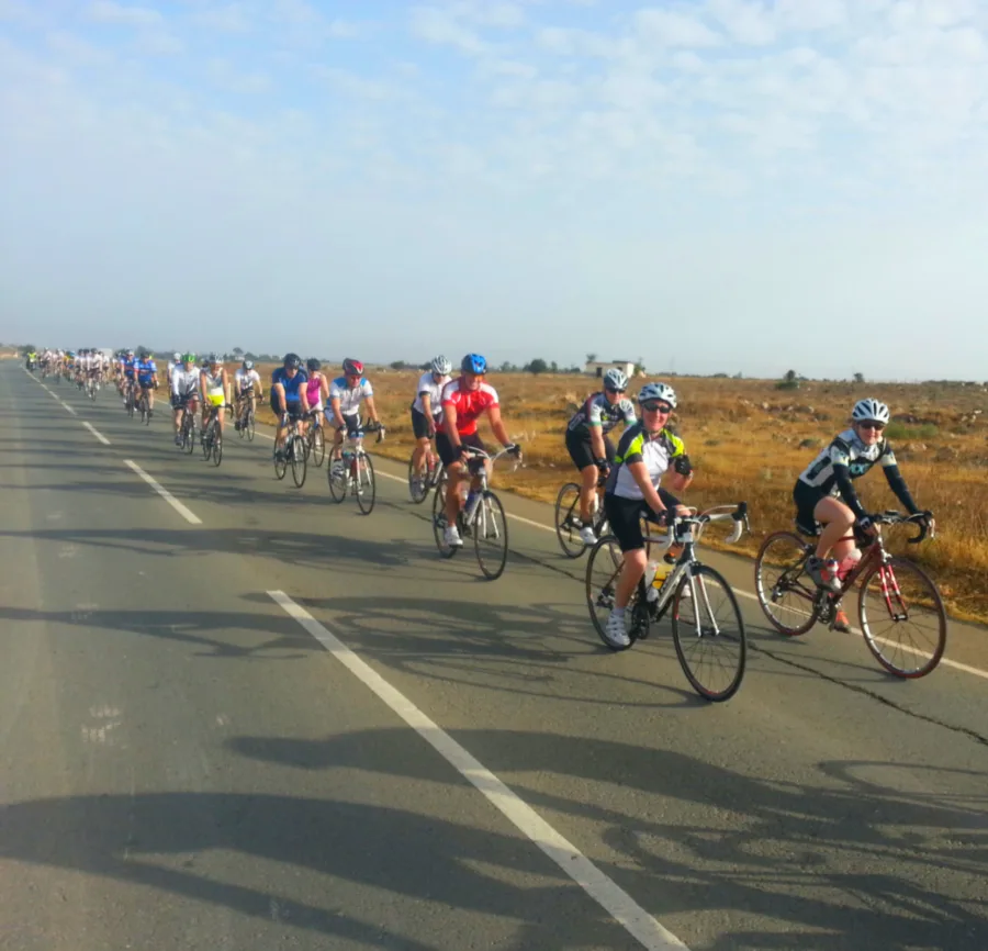 Riders spread out along a wide road through dry country