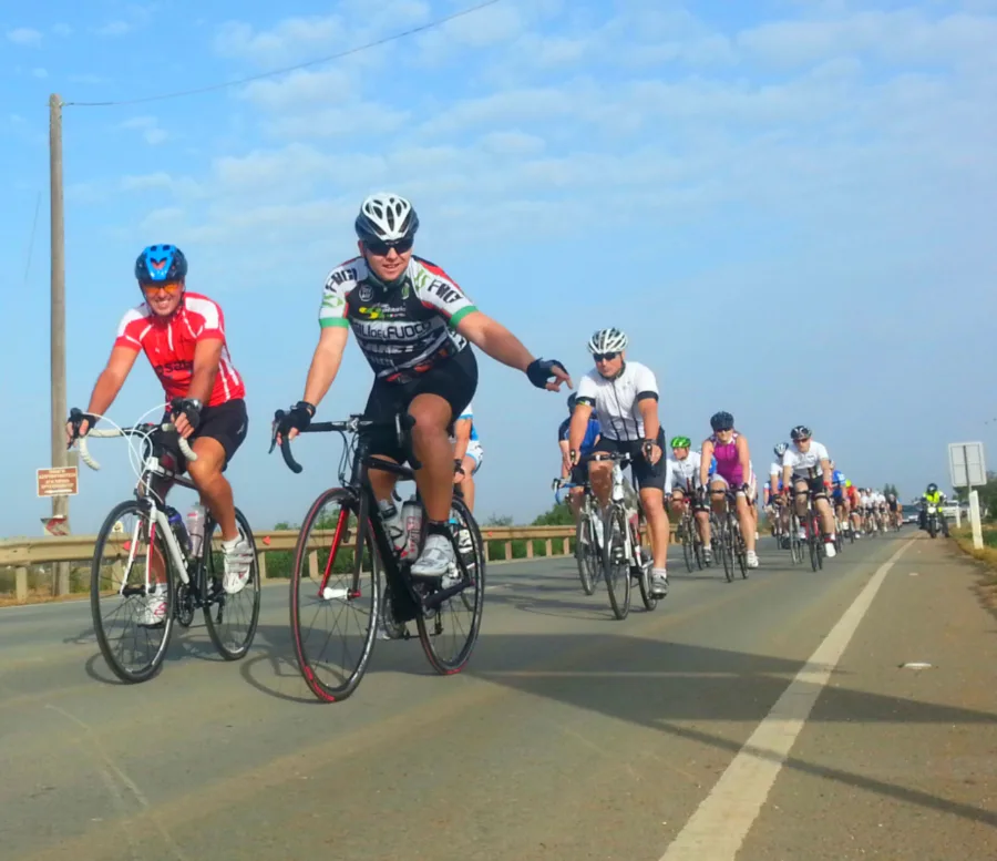 Riders in team kit racing side by side on a closed road