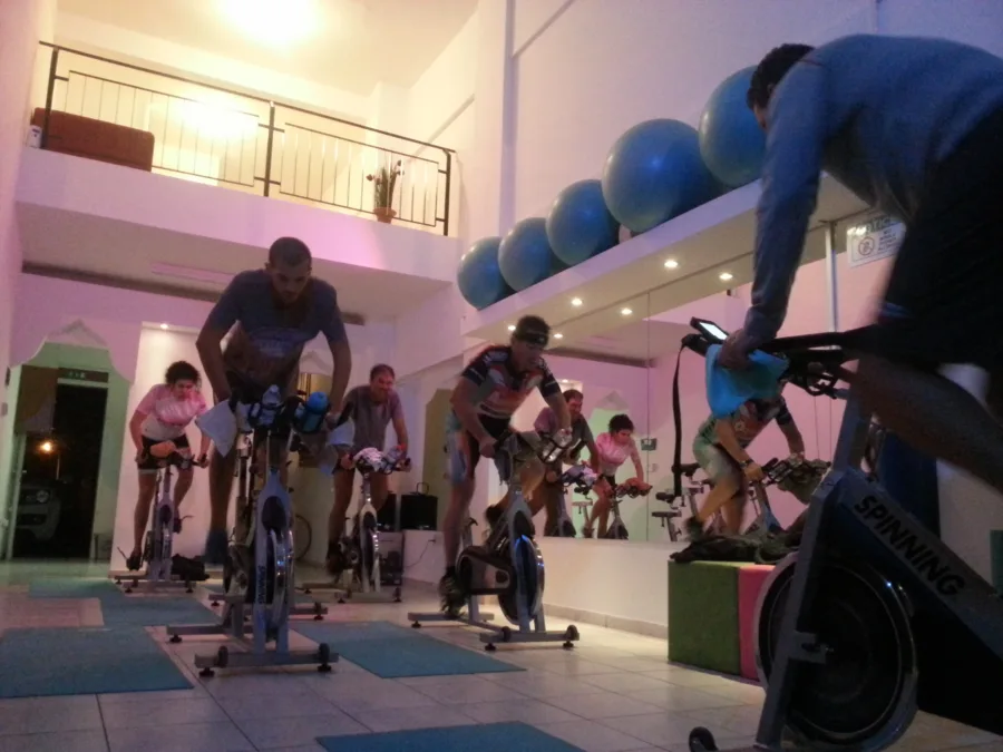 Riders working on stationary bikes in a studio with exercise balls on the wall