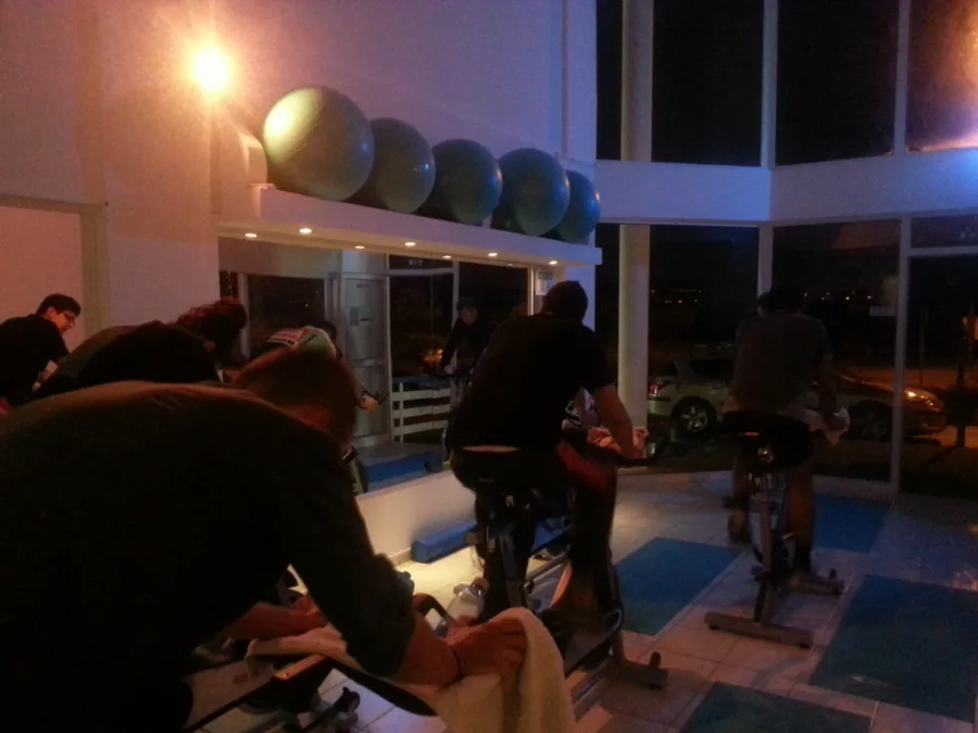A studio session under warm light, riders on stationary bikes