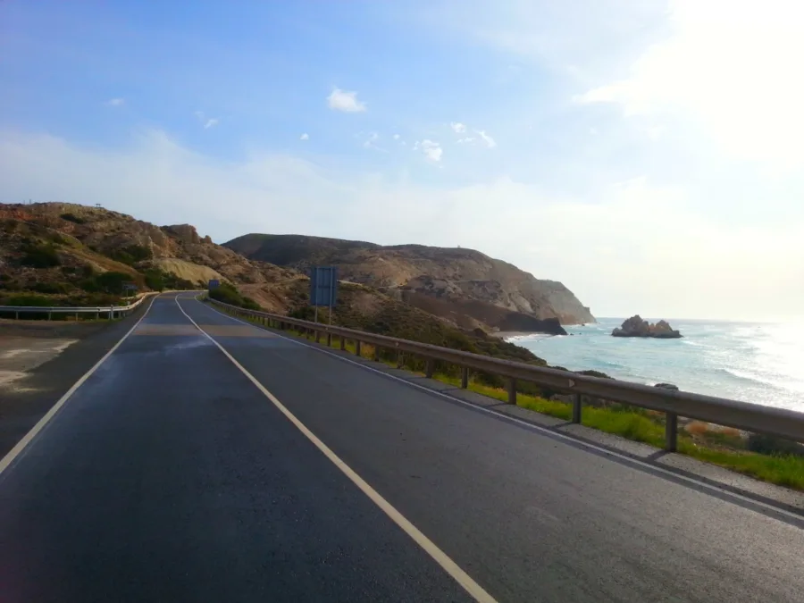 A road bending along a headland with the sea and a rocky point below