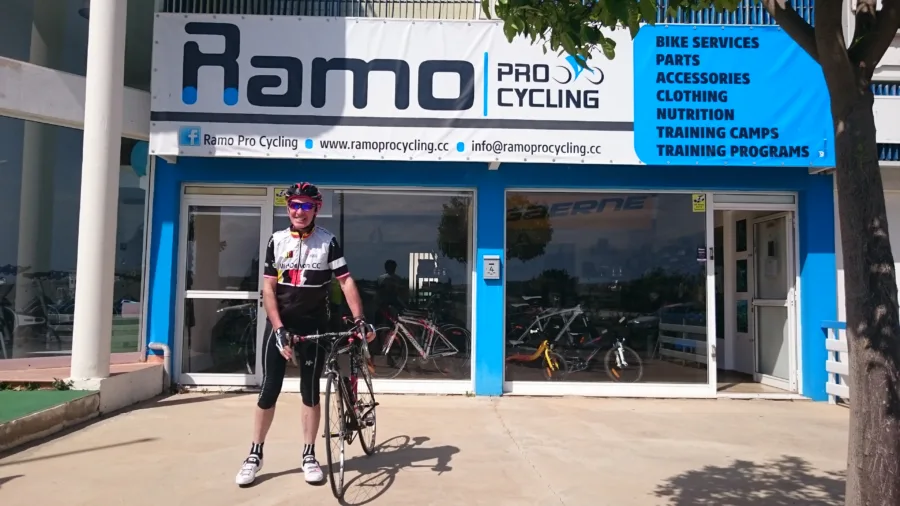 A rider passing the Ramo shopfront with its services banner above the glass