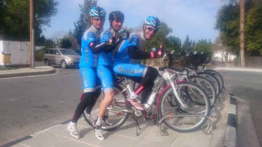 Three riders in Ramo kit standing with their bikes at the roadside