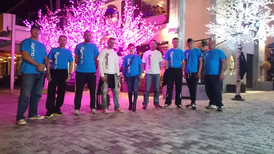 A group in Ramo shirts at night under a lit blossom tree