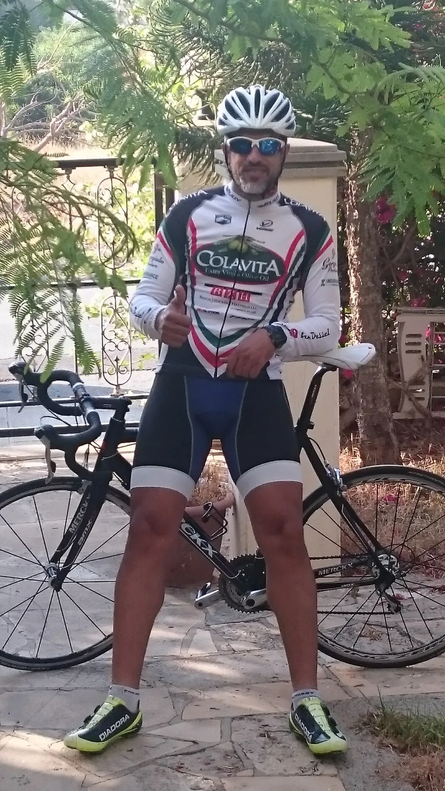 A rider standing over a road bike on a gravel path