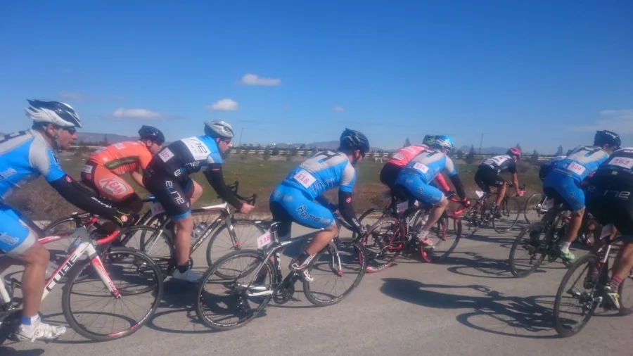 Riders in team kit riding through a corner on a closed road