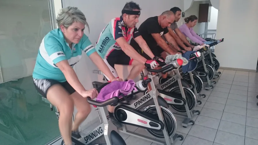 A line of people riding stationary bikes in a studio
