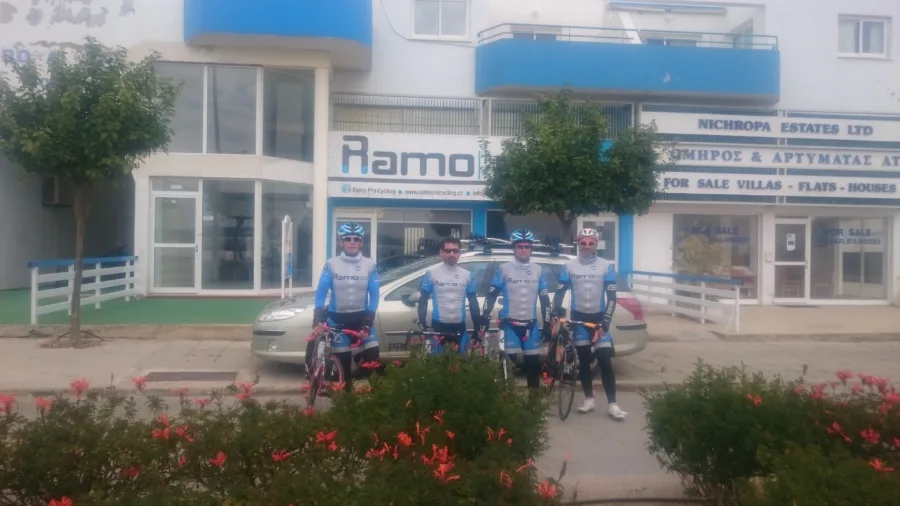 Riders in Ramo kit riding past the shop