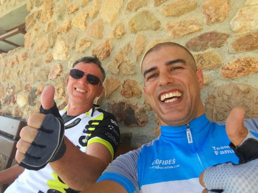 A selfie of two riders in front of a stone wall