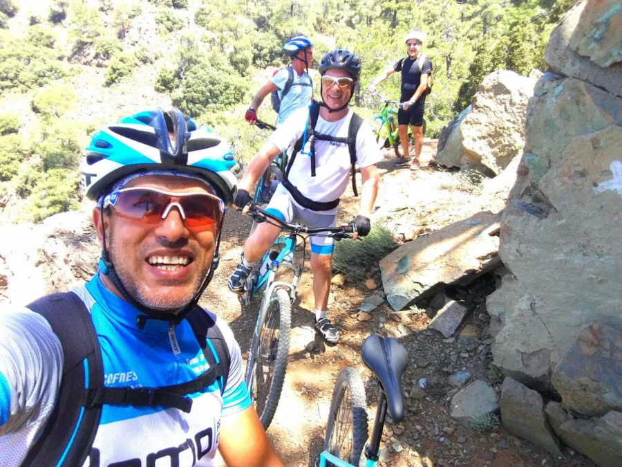 A selfie with mountain bikers picking through a rocky trail