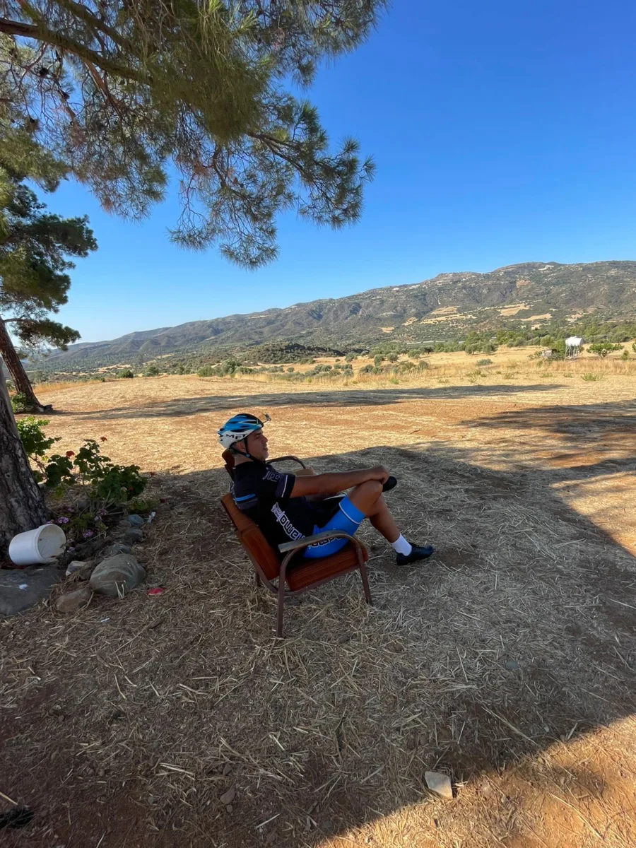 A rider sitting in an armchair in a field with mountains behind
