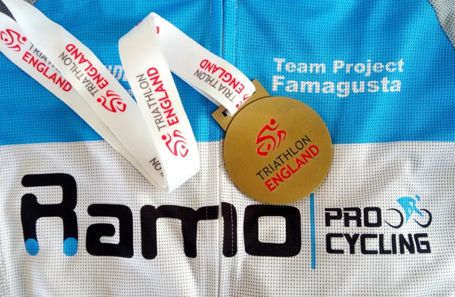 A Ramo Pro Cycling jersey with a Triathlon England medal and race numbers laid on it