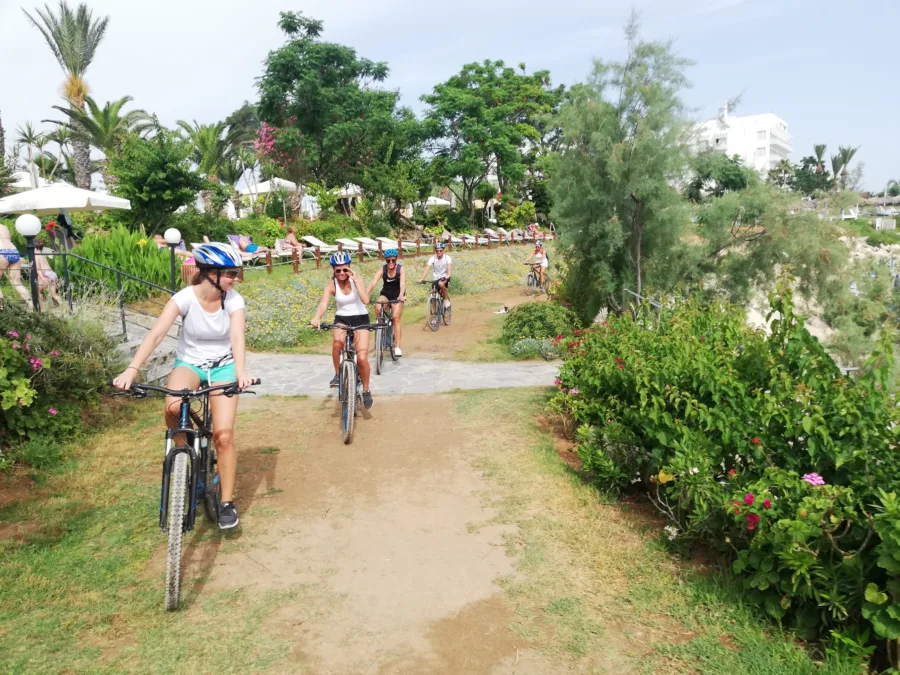 Riders on mountain bikes on a path through a planted garden