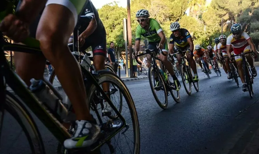 A close-up of riders’ legs and wheels inside a racing bunch
