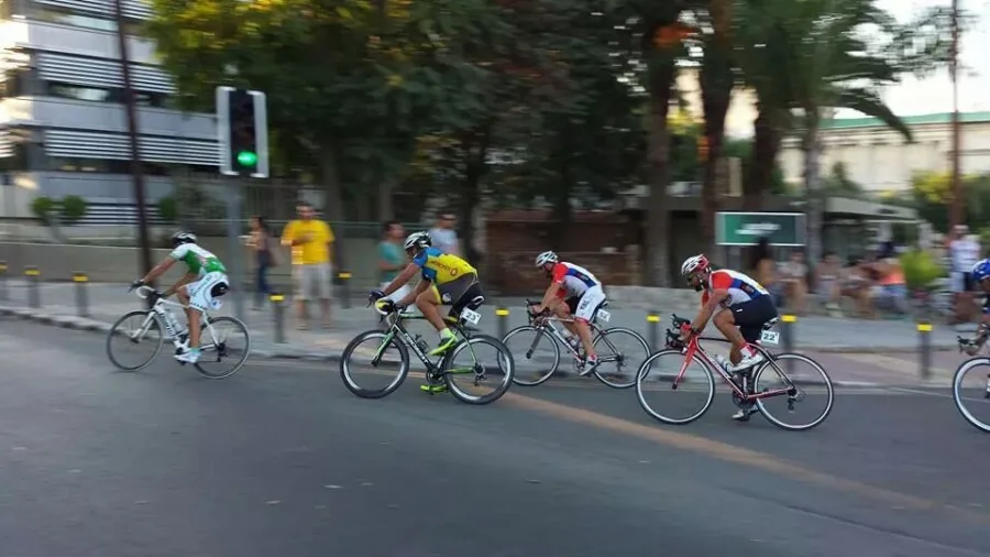 Riders racing through a road junction past traffic lights