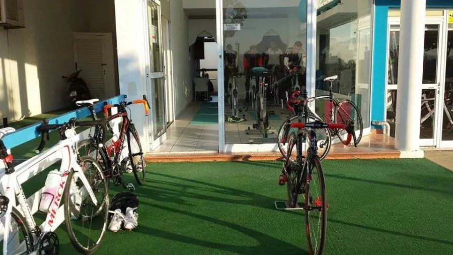 Road bikes lined up on the green floor inside the Ramo shop